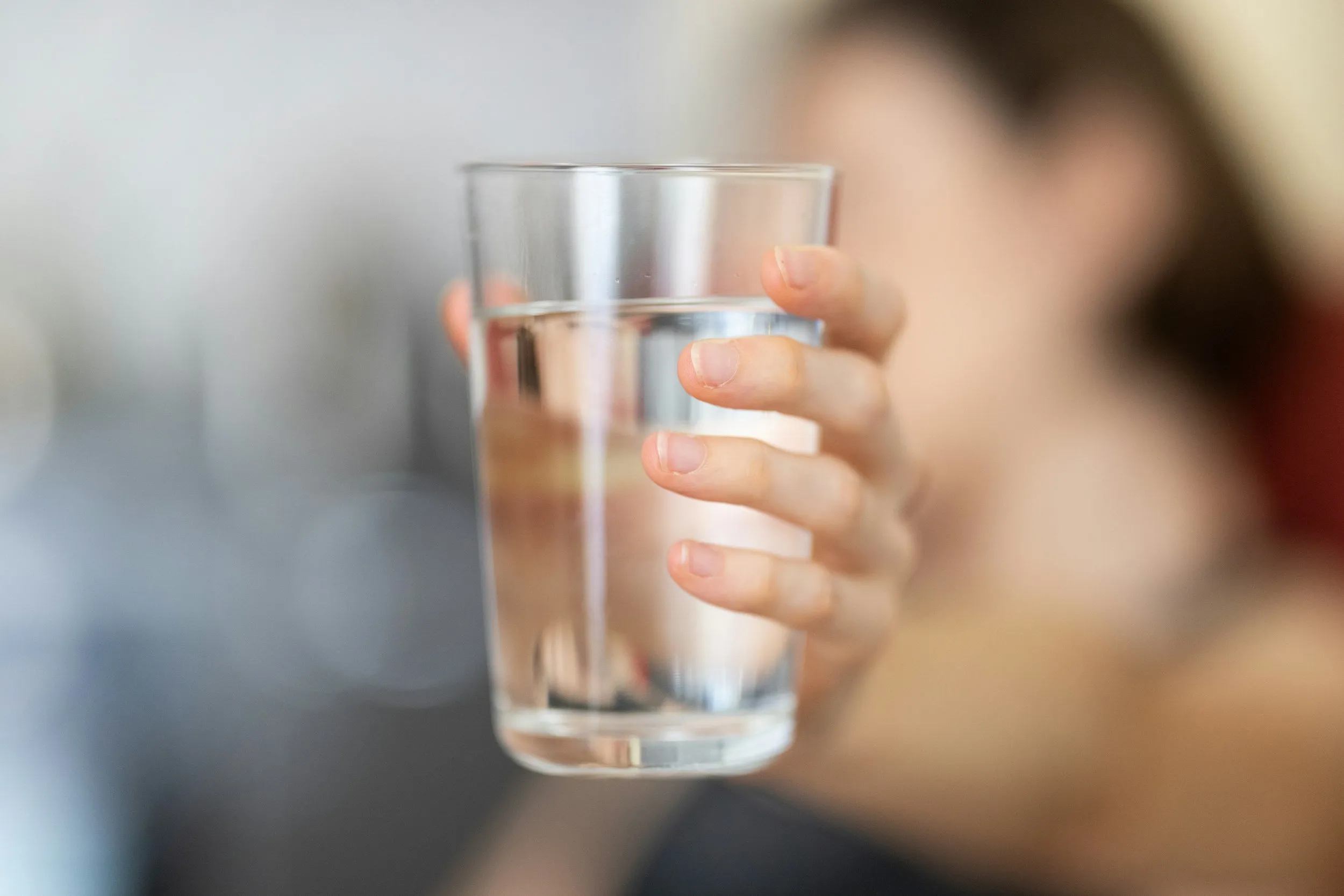 A person drinking a glass of water, illustrating swallowing therapy